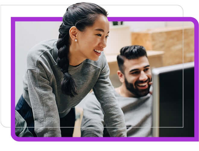 man and woman co workers looking at large monitor