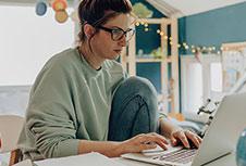 A women is working in laptop at home.