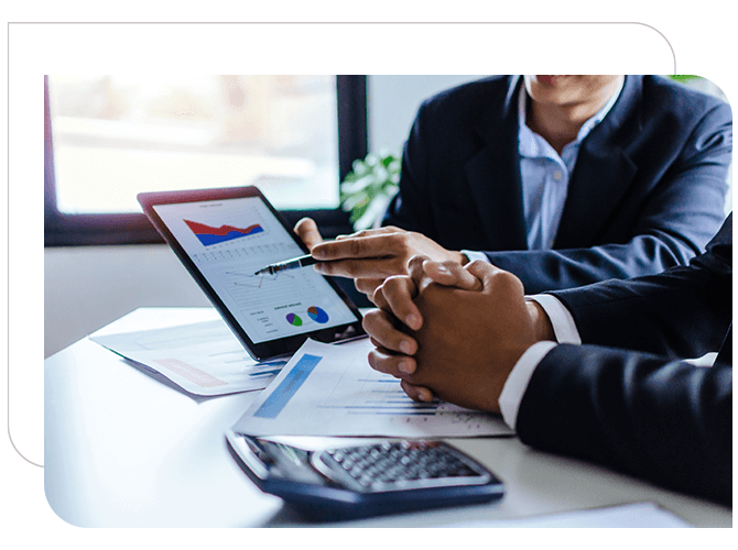 Business men at desk sharing financial documents, with a calulator on the table.