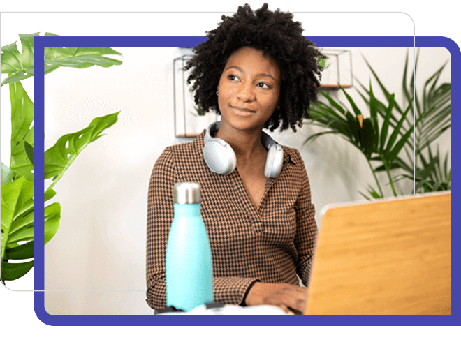 woman smile at laptop with plant and water bottle