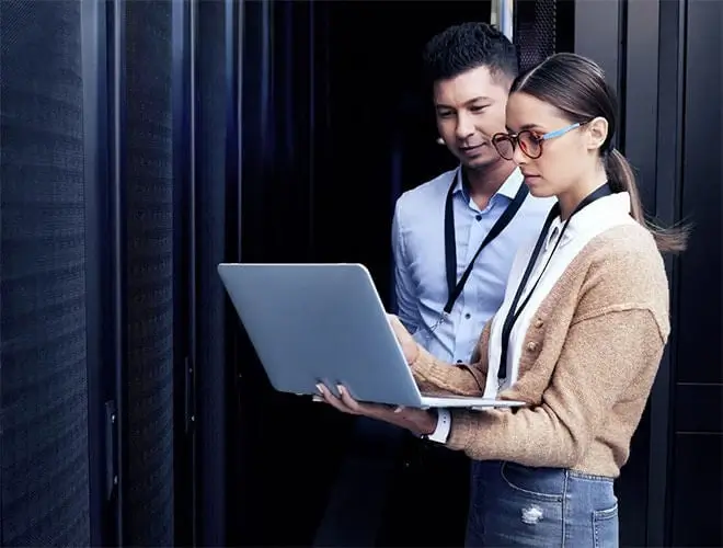 Shot of two technicians working together in a server room